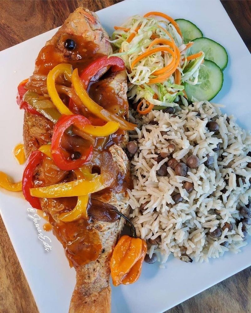 Prepared Caribbean plate with rice, vegetables, and sauced entree